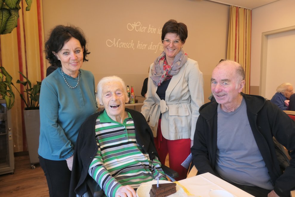 Vier Personen lächeln in die Kamera.