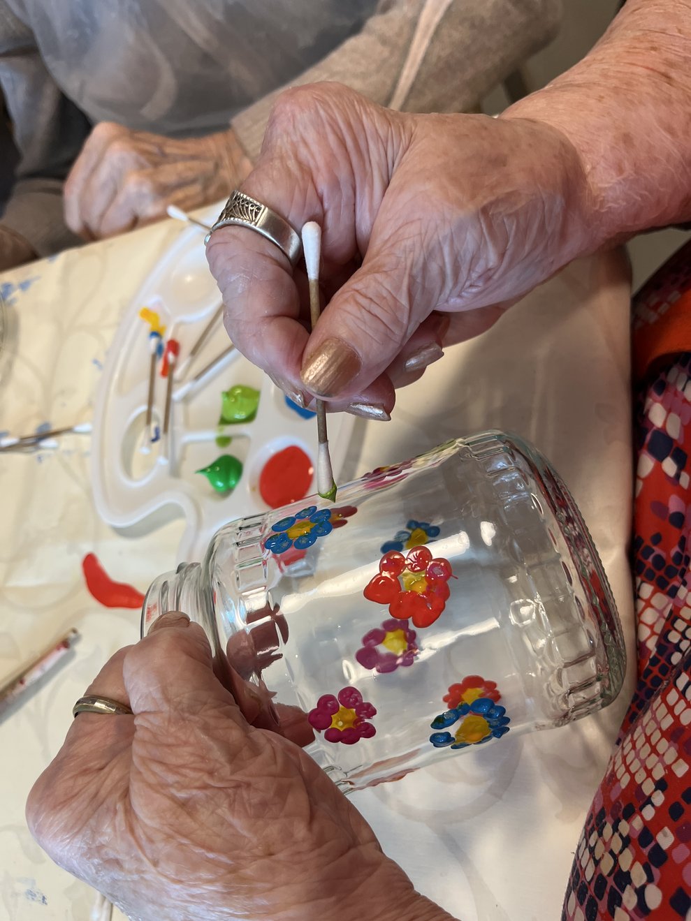 Hände beim Pinseln von Blumen