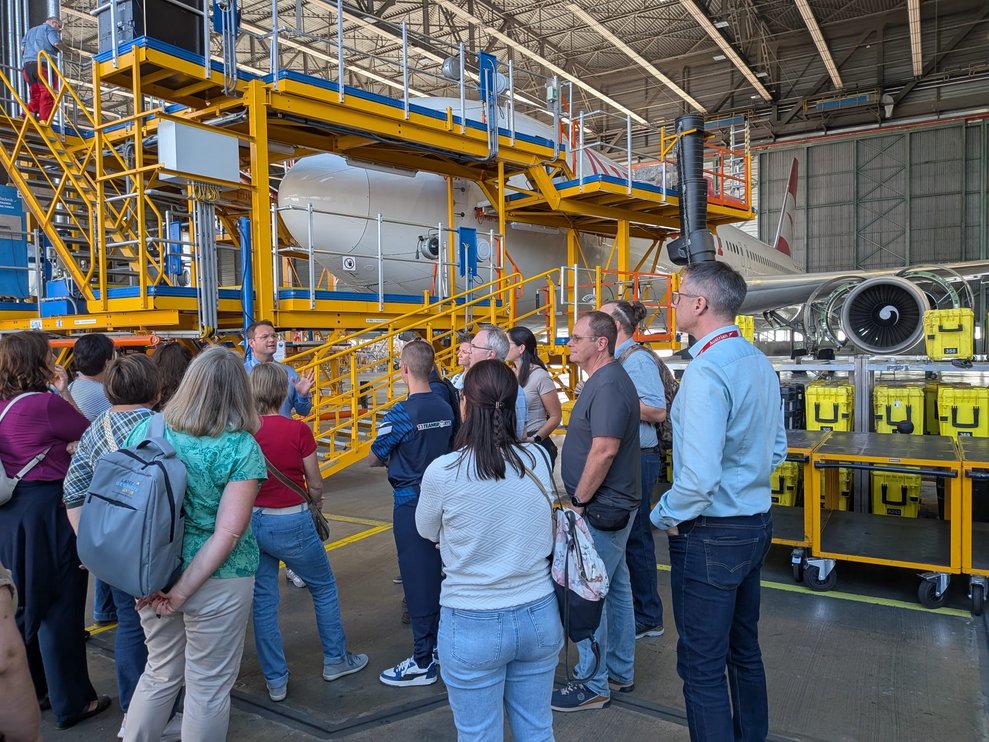 Mitarbeitergruppe besichtet Flugzeug in der Werkstatt