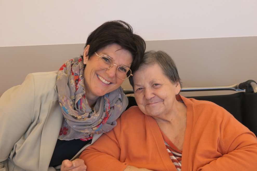 Zwei Damen lächeln in die Kamera.