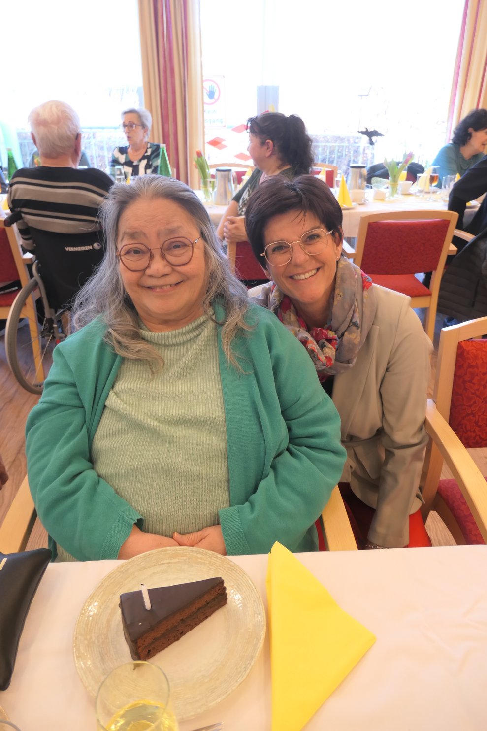 Zwei Damen lächeln in die Kamera.