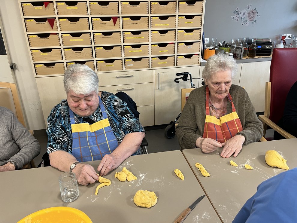 Bewohnerinnen beim Teig ausrollen