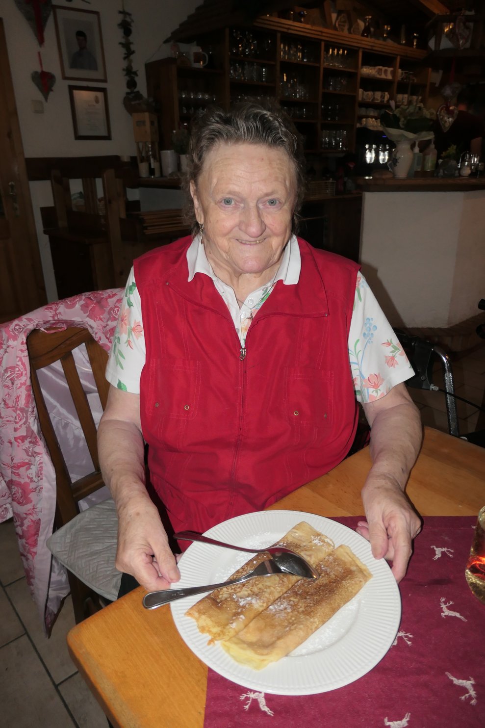 Eine Dame zeigt ein Teller mit Palatschinken in die Kamera.