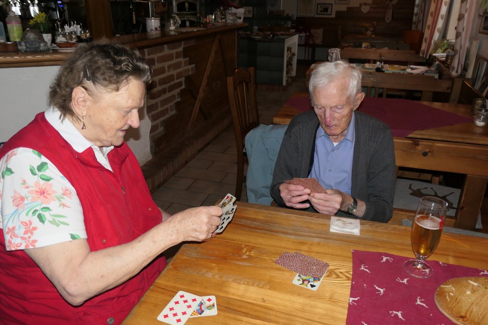 Eine Dame und ein Herr spielen Karten.