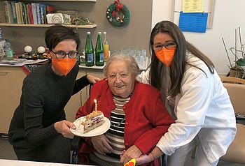 Drei Frauen mit Torte und Kerze