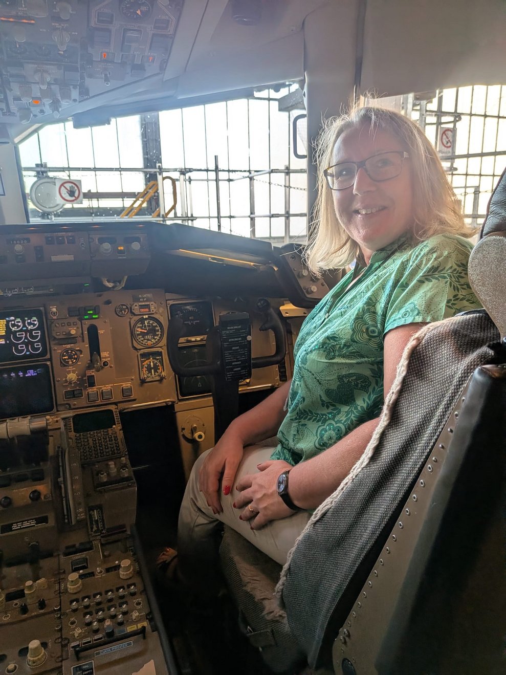 Frau sitzt lächelnd im Cockpit