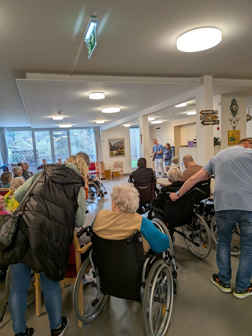 BewohnerInnen und Angehörige hören den Musikanten zu