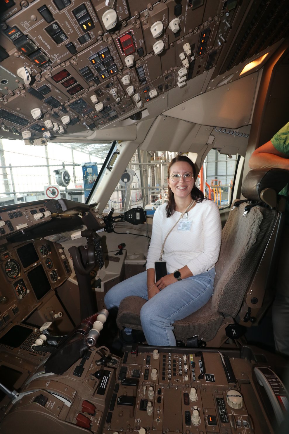 Frau sitzt lächelnd im Cockpit