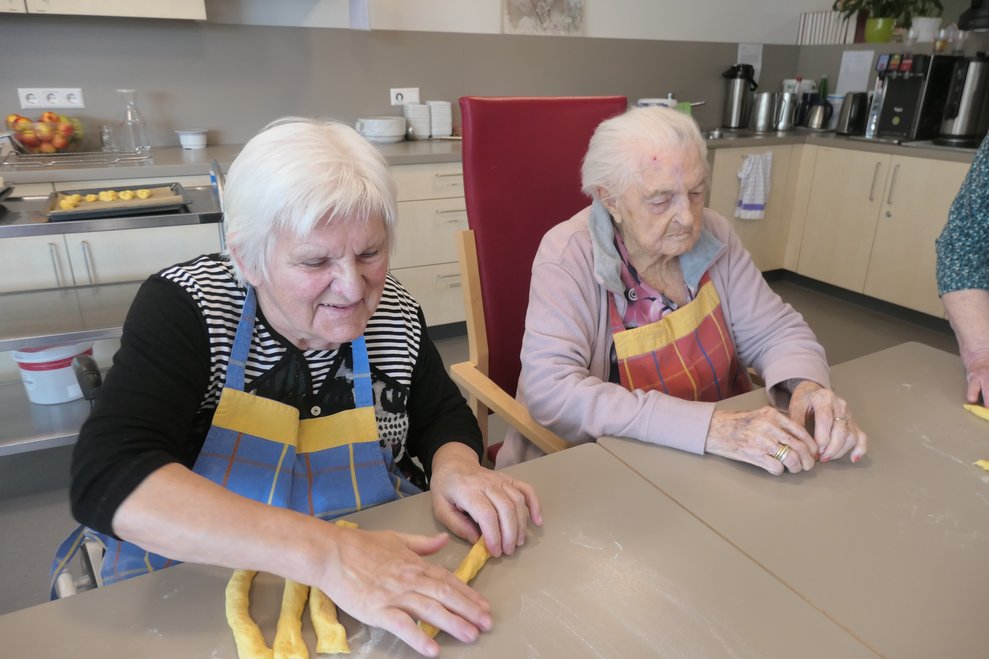 BewohnerInnen beim Teig ausrollen