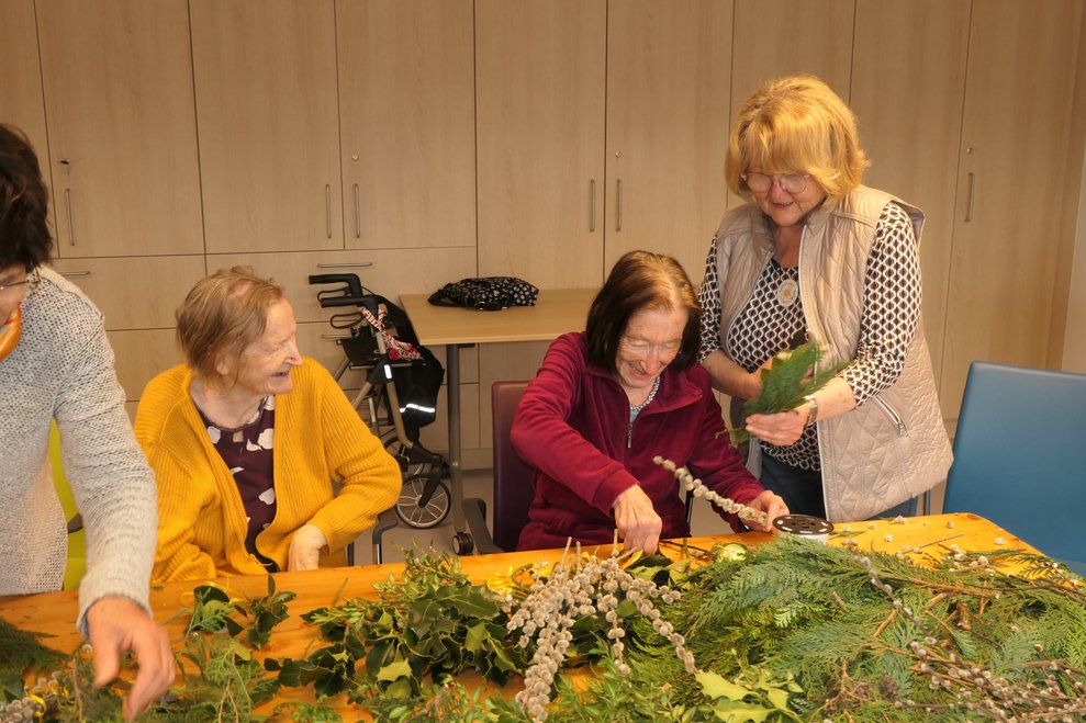 BewohnerInnen und Ehrenamtliche beim Palmbuschen binden