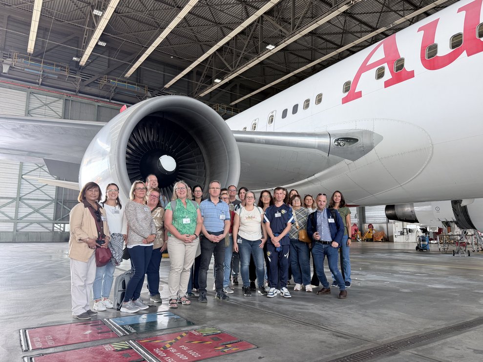 Gruppenfoto vor einem Flugzeugtriebwerk