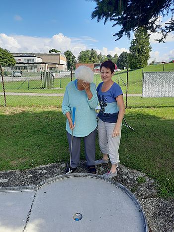 Eine Dame spielt Minigolf.
