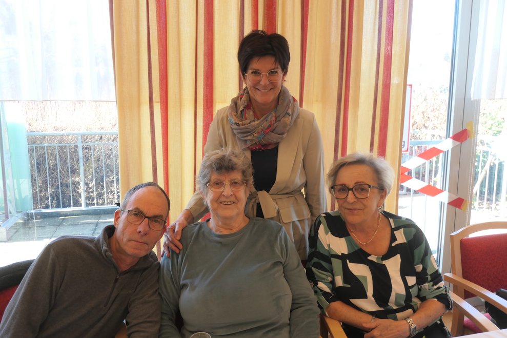 Vier Personen lächeln in die Kamera.