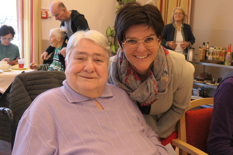 Zwei Damen lächeln in die Kamera.